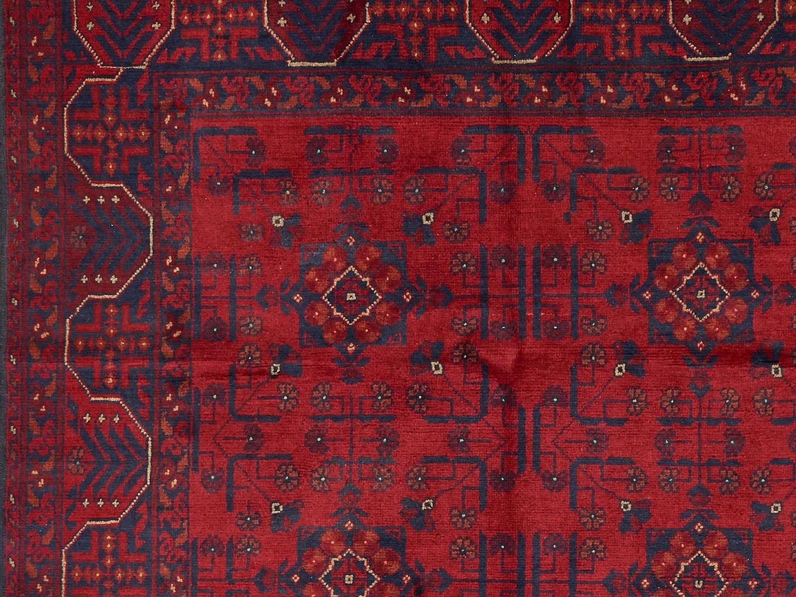 Afghan rug detail with repeating octagonal guls in deep red wool