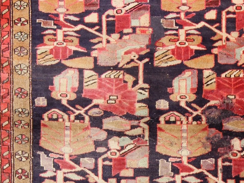 Tribal rug detail with irregular geometric motifs in undyed and madder wool